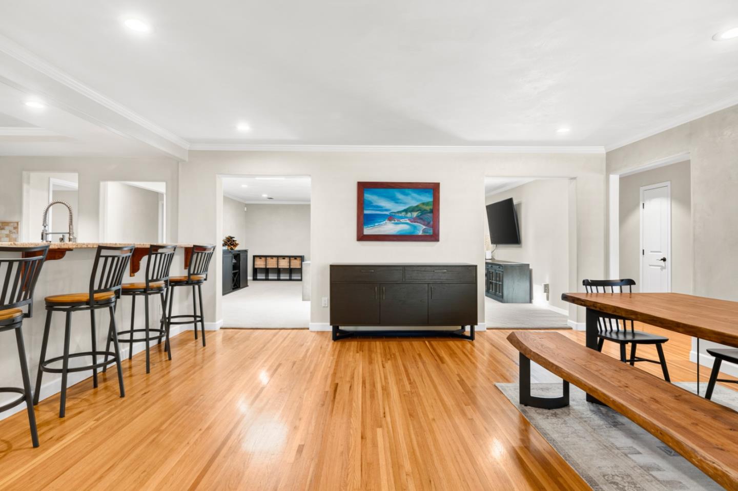 The open kitchen and dining area at 118 San Miguel Avenue, with hardwood floors, a breakfast bar, and a wood dining table